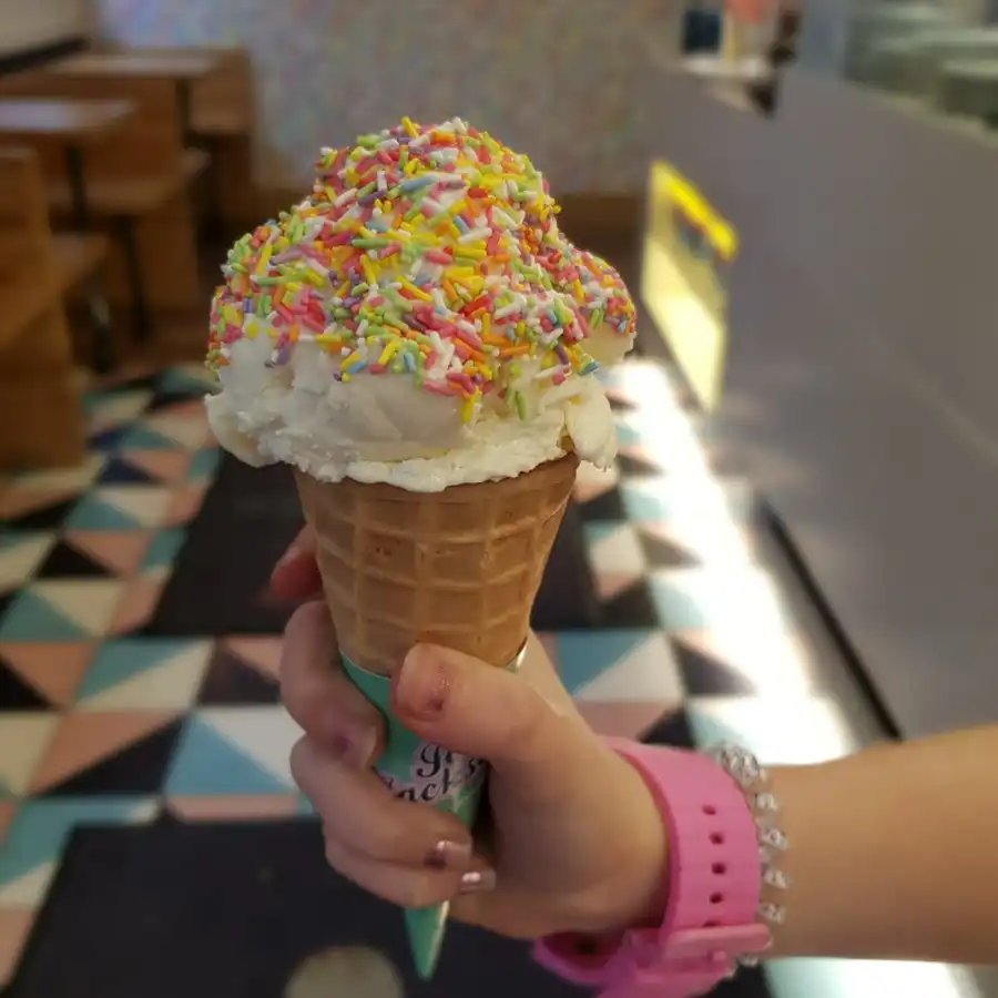 Vanilla ice cream in a cone with rainbow sprinkles and a wafer with joe jackson name on it