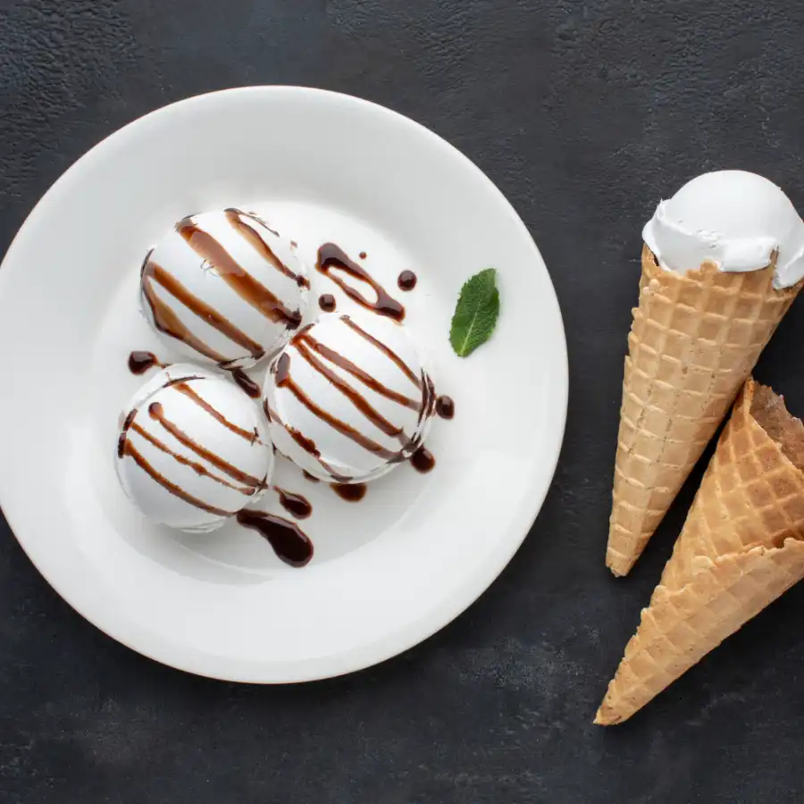 Three vanilla scoop on plate with chocolate sauce and mint leaf, one vanilla scoop in cone and cone is lying on floor